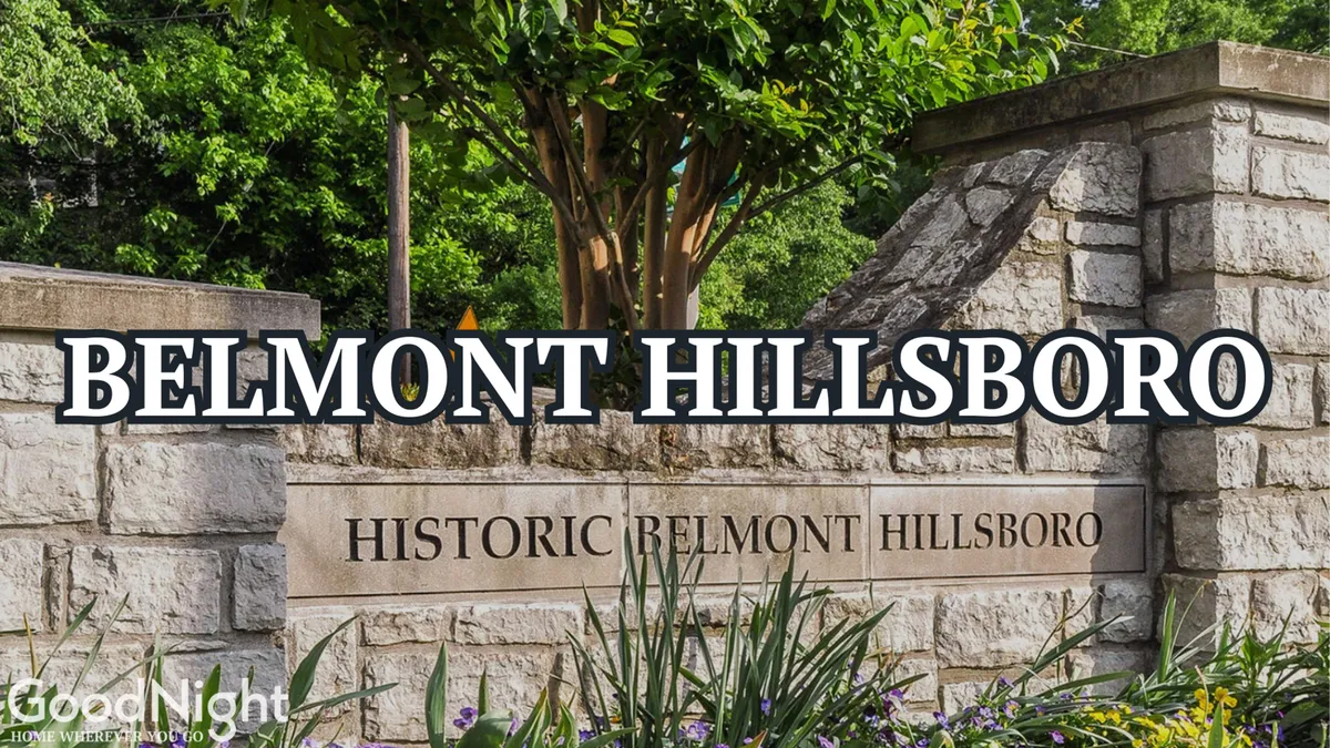 A welcoming exterior view of the Belmont Hillsboro neighborhood, with clear signage, landscaped gardens, and surrounding trees. The setting is bright and inviting, suggesting a pleasant environment for walking and exploring local conveniences.