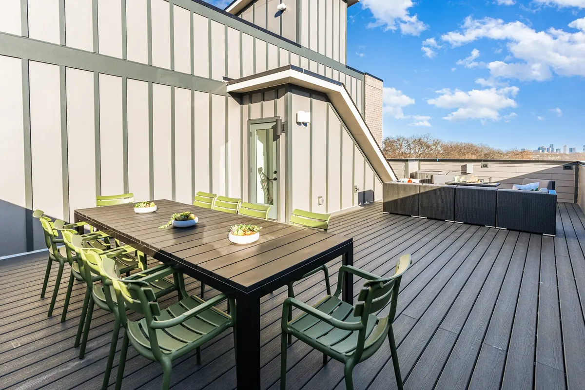 A stylish outdoor dining area featuring a dining table with green chairs and a lounge area, set for al fresco meals and vibrant group gatherings.