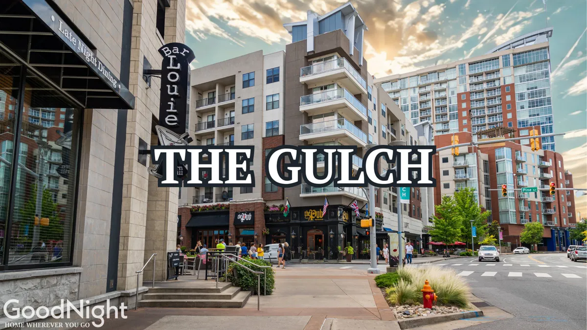 A bustling Nashville street scene featuring Bar Louie, other shops, and modern buildings. People are seen enjoying the vibrant street activity, suggesting a lively neighborhood with accessible amenities. Outdoor signage and storefronts indicate the presence of local services and gathering spots.